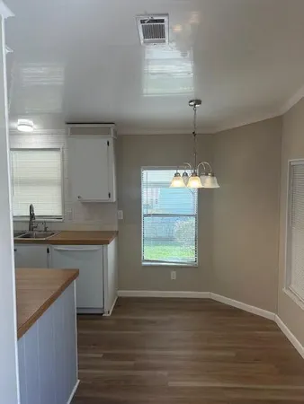 a view of a kitchen with a sink cabinets and wooden floor