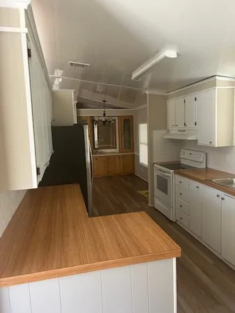a kitchen with kitchen island a counter top space a sink stainless steel appliances and cabinets