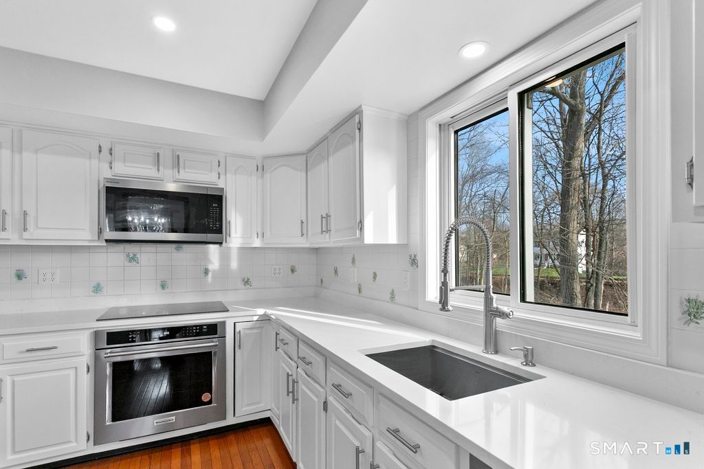 6 Stonegate Lane Shelton, CT 06484 - Photo 8 of 37 a kitchen with granite countertop a sink stainless steel appliances and cabinets