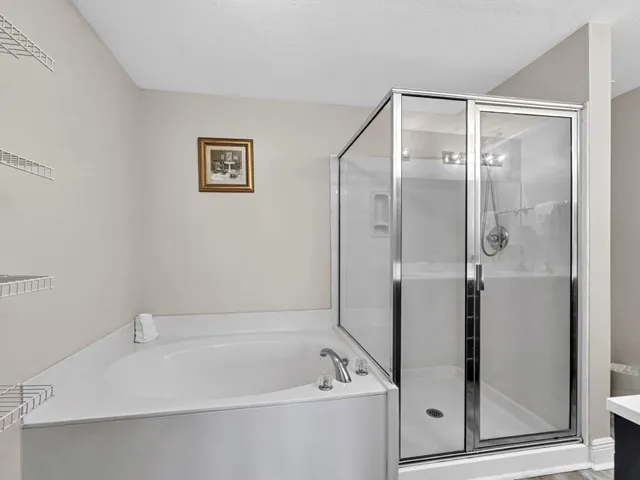 a white bath tub sitting next to a shower