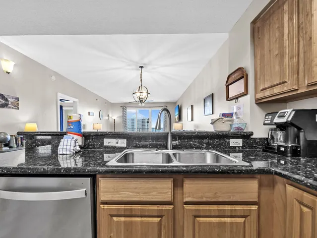 a kitchen with granite countertop stainless steel appliances a sink and cabinets