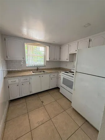 a kitchen with cabinets stainless steel appliances a sink and a window