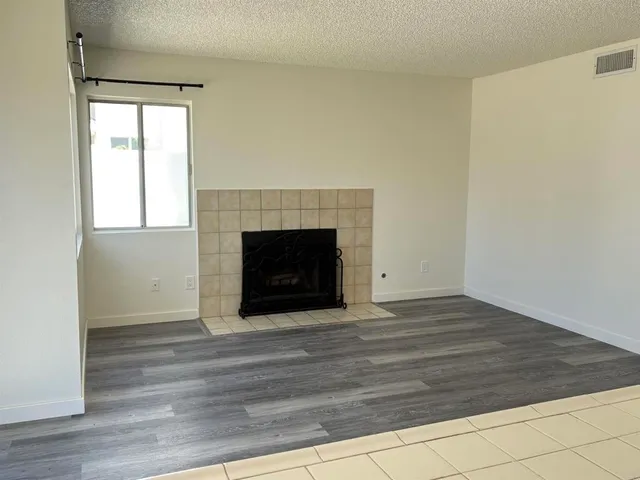 a view of empty room with wooden floor and fireplace