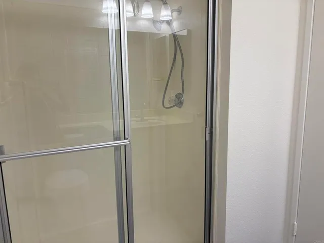 a bathroom with a glass shower door and a shower