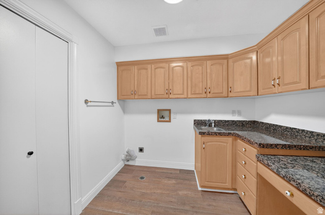883 East 700 South Springville, UT 84663 - Photo 30 of 59 Utility space featuring wood-finish flooring, light wood cabinetry, and dark speckled countertops