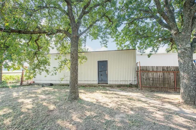 a view of a house with a large tree and a yard