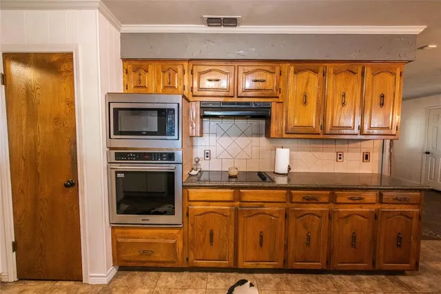 a kitchen with stainless steel appliances granite countertop a stove and a microwave