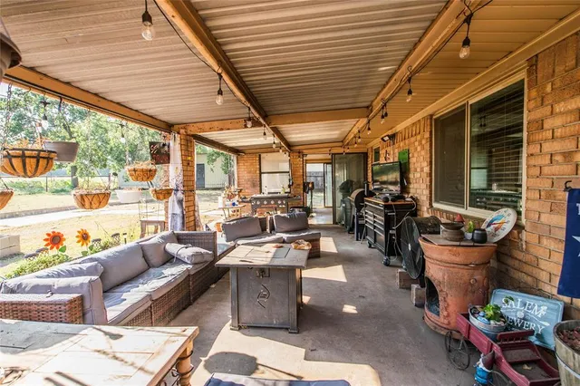a living room with patio furniture and a potted plant