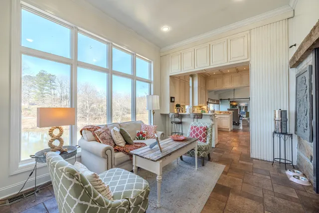 a living room with fireplace furniture and a large window