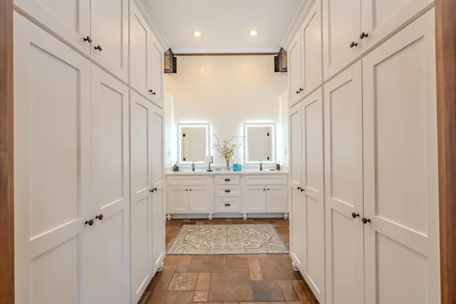 a bathroom with white walls vanity and a mirror