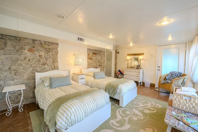 a spacious bedroom with a bed and glass table