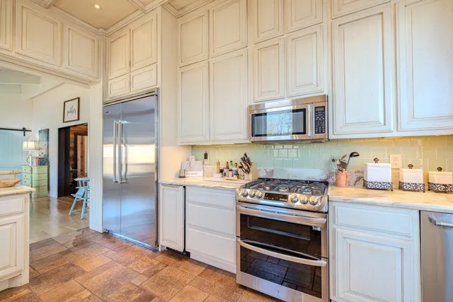 a kitchen with appliances a stove and cabinets