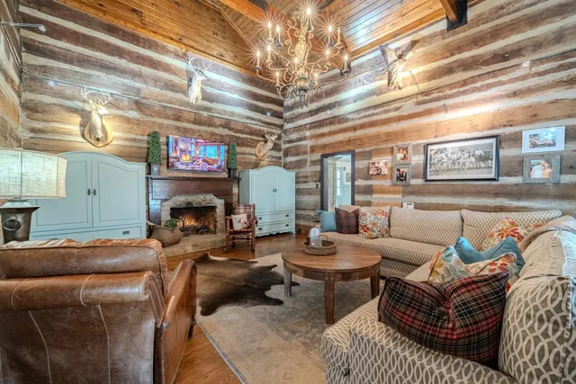 a living room with furniture a fireplace and a chandelier