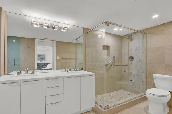 a bathroom with a shower sink mirror and toilet