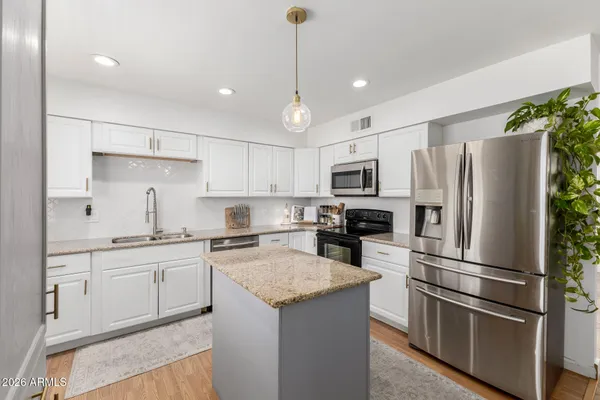 a kitchen with stainless steel appliances a refrigerator sink and microwave