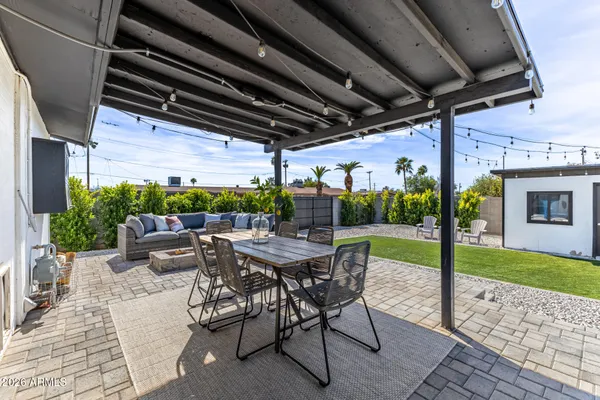 a view of patio with a table and chairs and potted plants