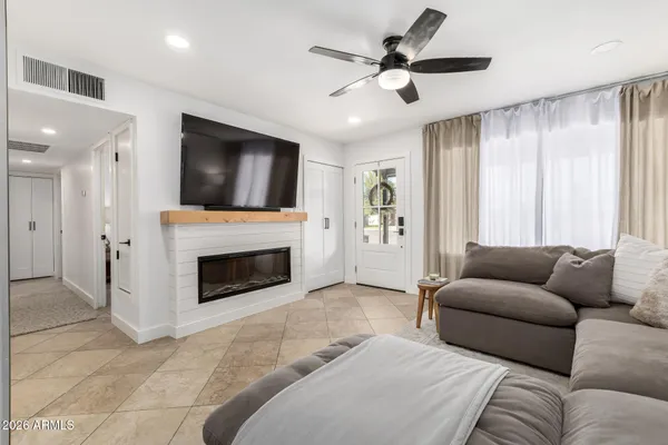 a living room with furniture a fireplace and a flat screen tv