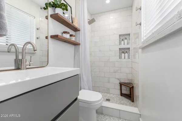 a bathroom with a sink a toilet and shower curtain