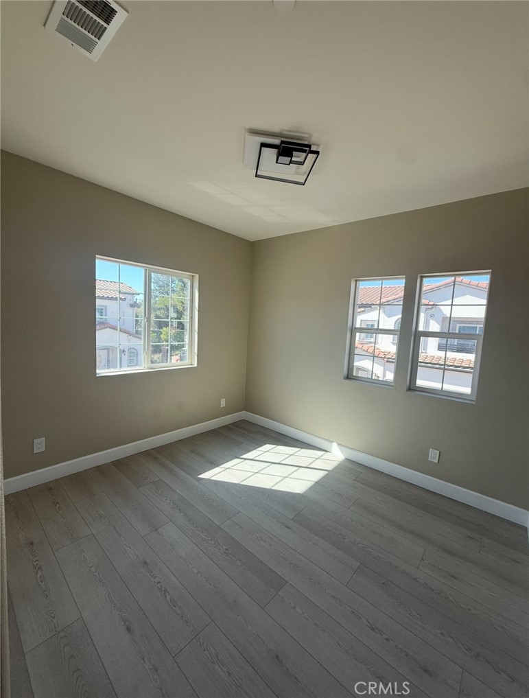 15909 Merrill Avenue, Unit 10 Fontana, CA 92335 - Photo 11 of 14 wooden floor in an empty room with a window