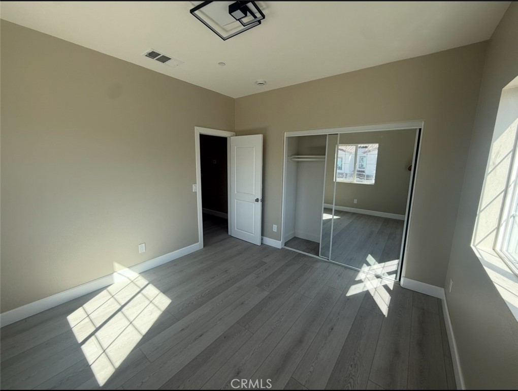 15909 Merrill Avenue, Unit 10 Fontana, CA 92335 - Photo 13 of 14 a view of wooden floor and windows in a room
