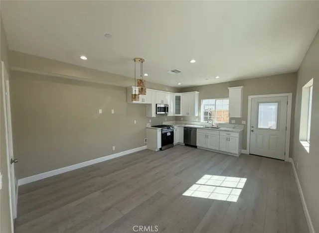 a view of a kitchen with a sink wooden floor and a kitchen