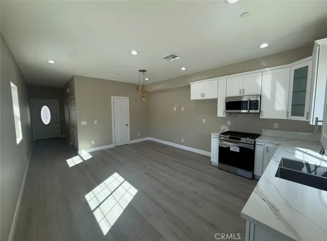 a kitchen with stainless steel appliances granite countertop a stove a sink and a refrigerator