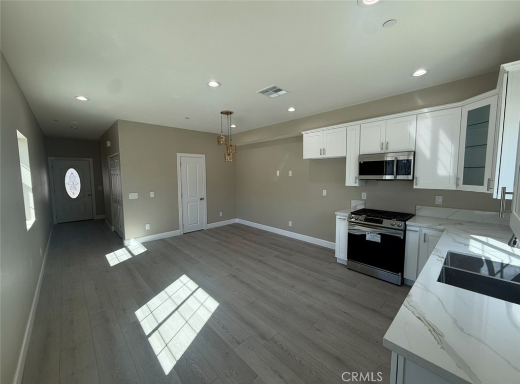 15909 Merrill Avenue, Unit 10 Fontana, CA 92335 - Photo 3 of 14 a kitchen with stainless steel appliances granite countertop a stove a sink and a refrigerator