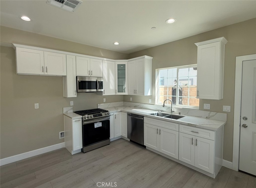 15909 Merrill Avenue, Unit 10 Fontana, CA 92335 - Photo 4 of 14 a kitchen with a sink stove and microwave
