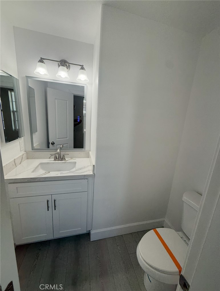 15909 Merrill Avenue, Unit 10 Fontana, CA 92335 - Photo 7 of 14 a bathroom with a toilet a sink and mirror