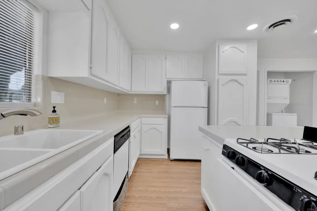9015 Campo Road Spring Valley, CA 91977 - Photo 16 of 58 a kitchen with granite countertop a sink stove and refrigerator