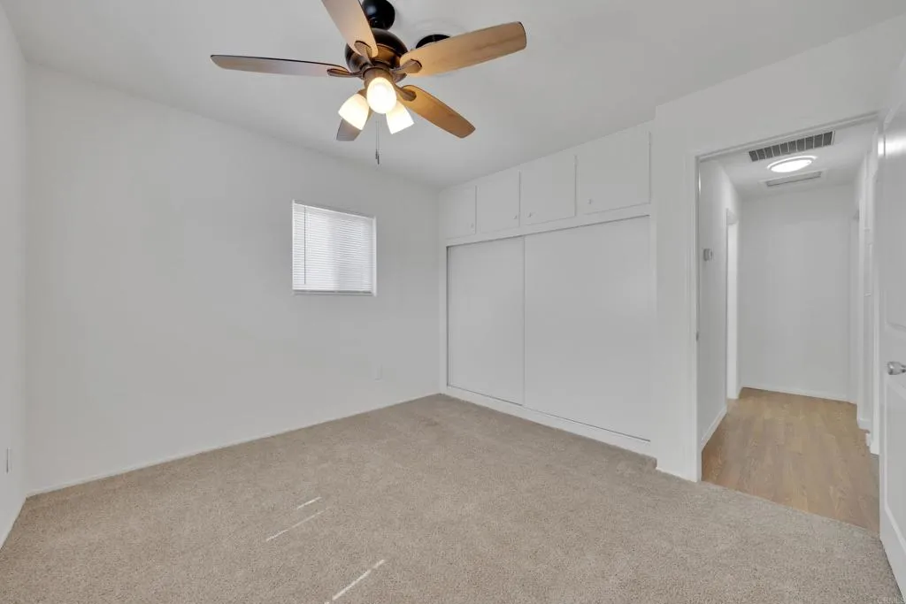 9015 Campo Road Spring Valley, CA 91977 - Photo 26 of 58 an empty room with a chandelier fan and windows