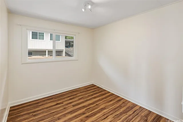 a view of a room with wooden floor and a window
