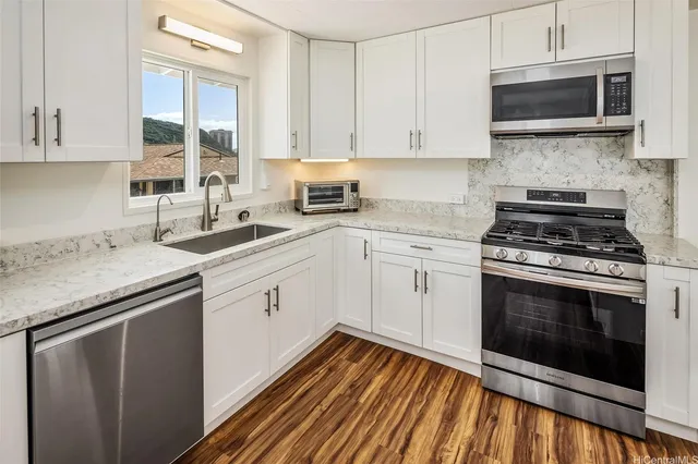 a kitchen with a sink stove and microwave