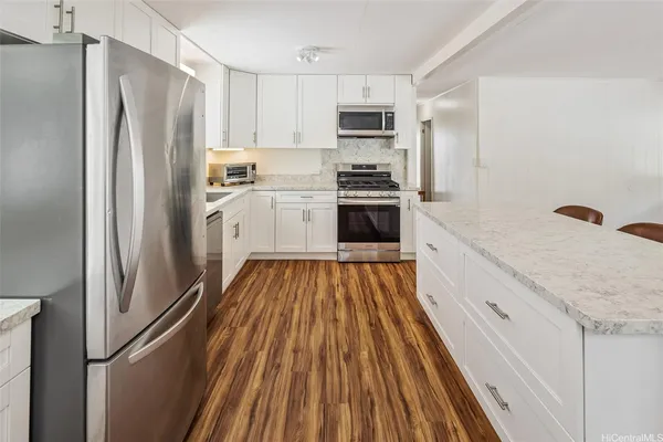 a kitchen with white cabinets and stainless steel appliances