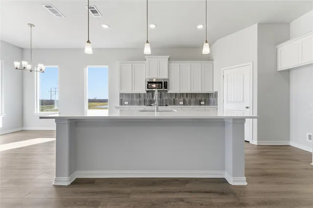 a kitchen with a sink cabinets and wooden floor