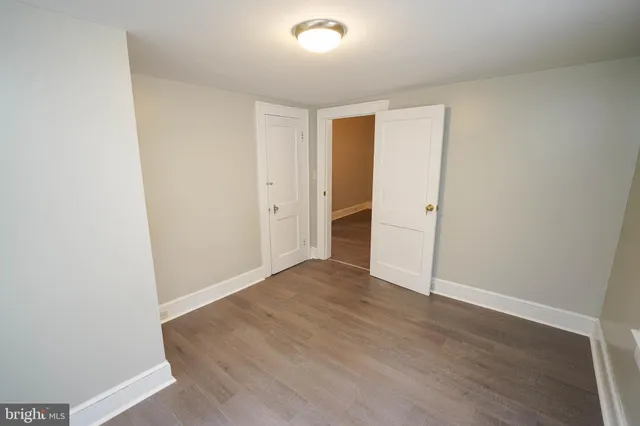 a view of an empty room with windows and closet
