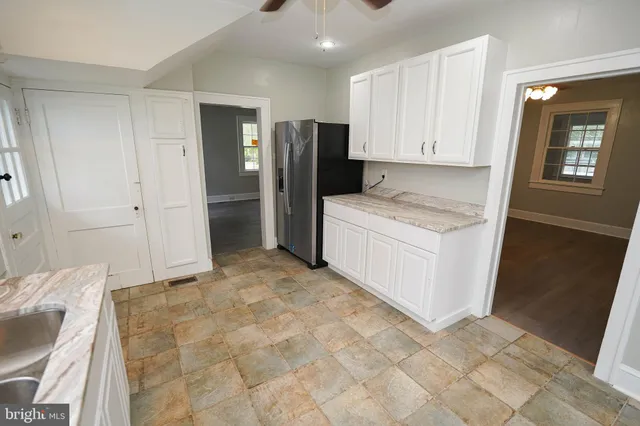 a spacious bathroom with a granite countertop sink and a mirror