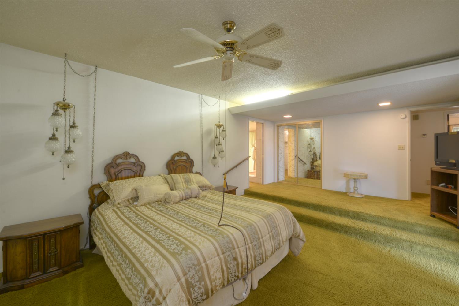 1471 Highway 33 Gustine, CA 95322 - Photo 26 of 57 a large bedroom with a bed and a chandelier