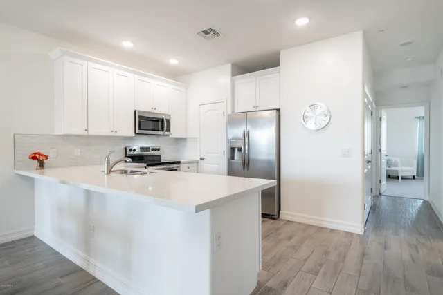 a kitchen with stainless steel appliances a refrigerator sink and microwave