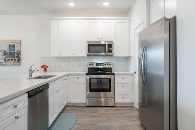 a kitchen with white cabinets and stainless steel appliances