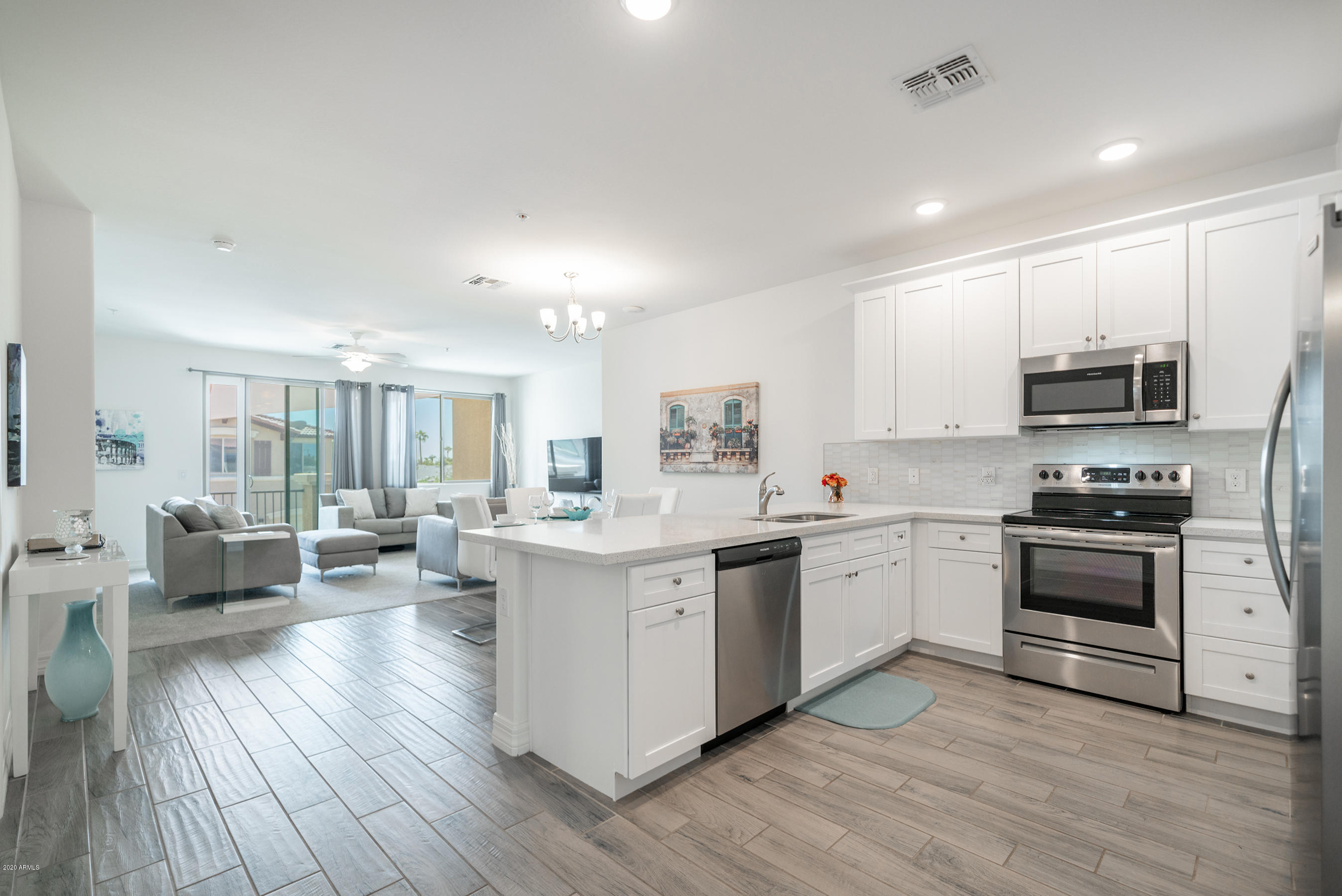 7820 East Baseline Road, Unit 208 Mesa, AZ 85209 - Photo 15 of 29 a kitchen with stainless steel appliances granite countertop a stove top oven a sink dishwasher a refrigerator and white cabinets with wooden floor
