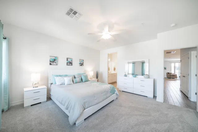 a bedroom with bed and white cabinets