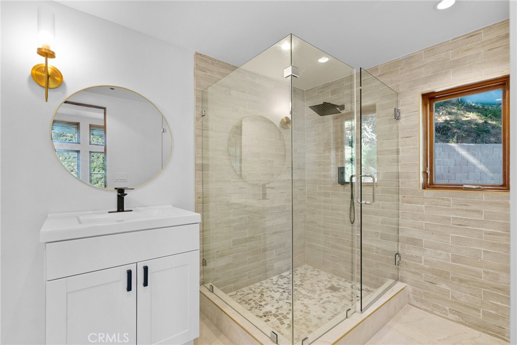51422 Partington Ridge Road Big Sur, CA 93920 - Photo 15 of 36 a bathroom with a sink a mirror a vanity and shower