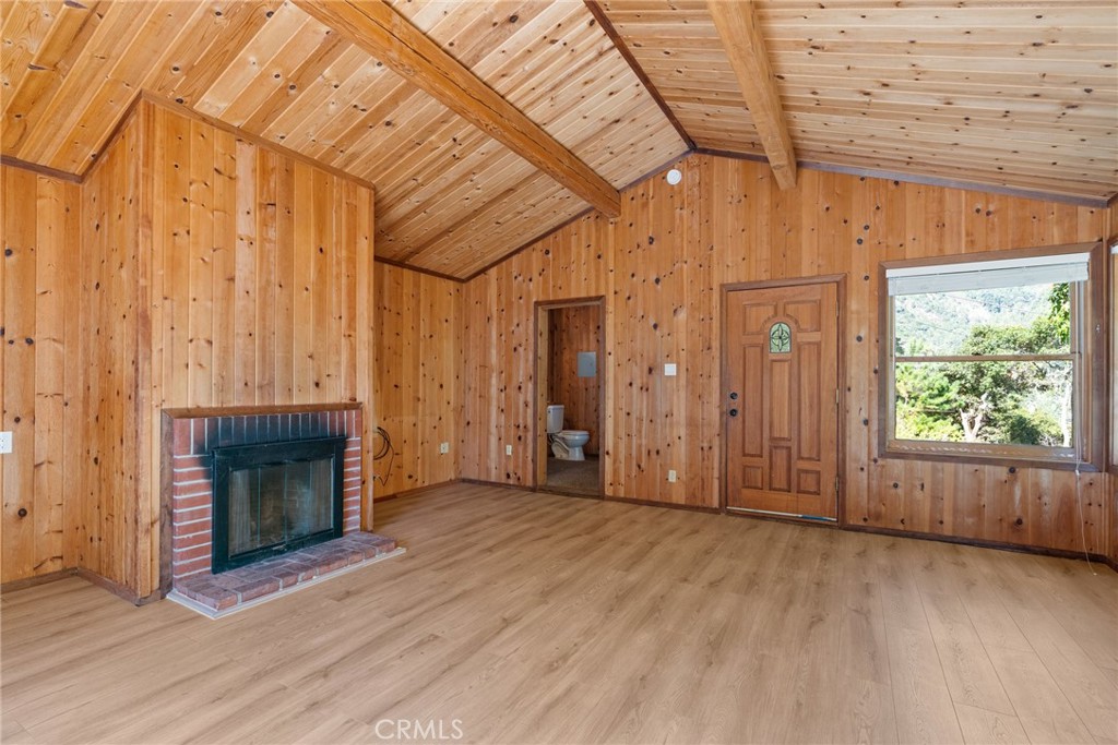 51422 Partington Ridge Road Big Sur, CA 93920 - Photo 28 of 36 an empty room with wooden floor fireplace and windows