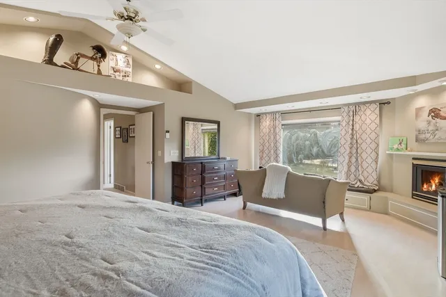 a spacious bedroom with a large bed and a chandelier