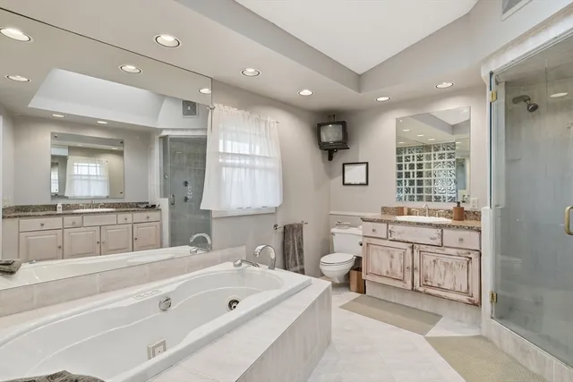 a spacious bathroom with a double vanity sink a mirror and a bathtub