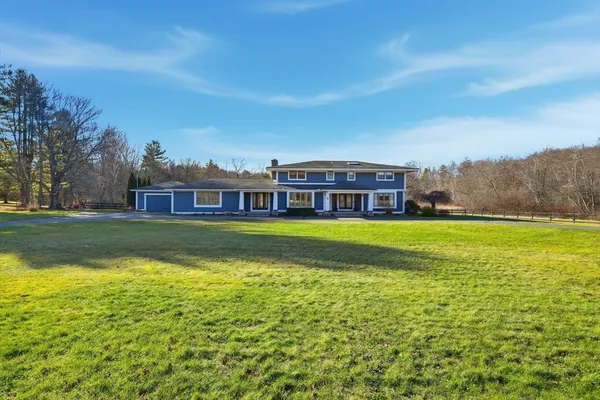 a view of building with a big yard and large trees