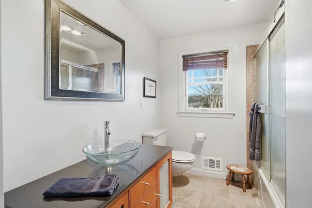 a bathroom with a toilet a sink and mirror