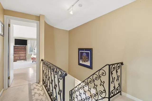 a view of a hallway with wooden floor and stairs