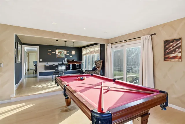 a room with pool table and windows